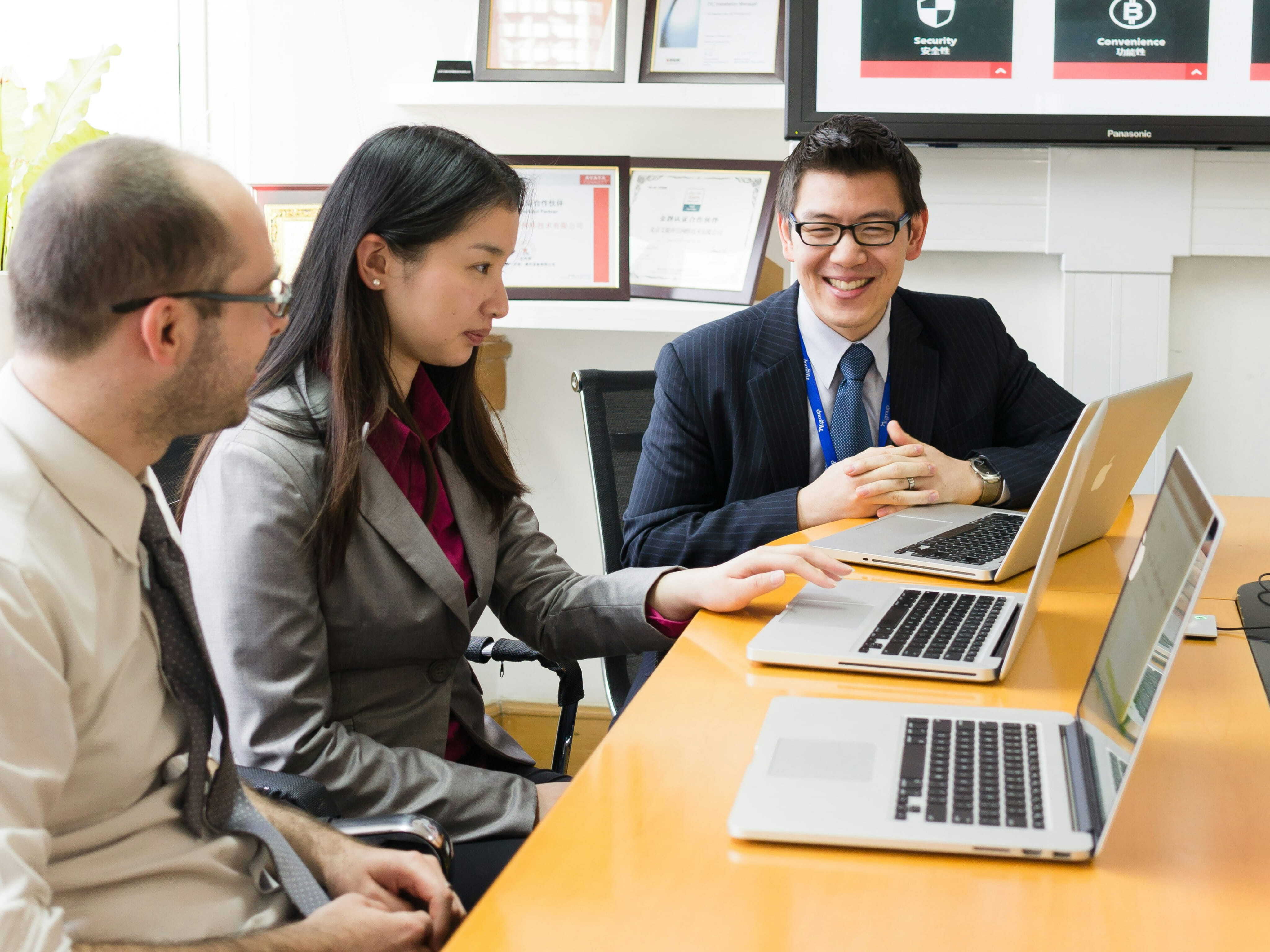 Office workers sitting at a table with laptops